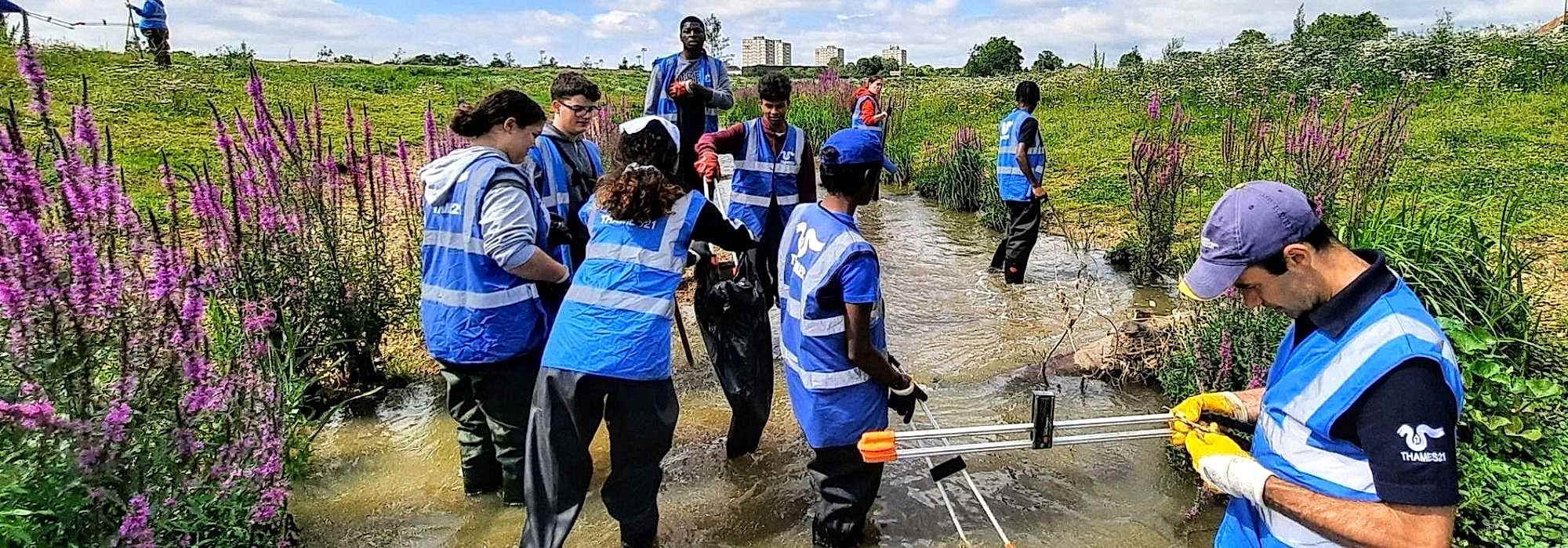 Volunteers in Thames21 high vis jackets working in a small waterway